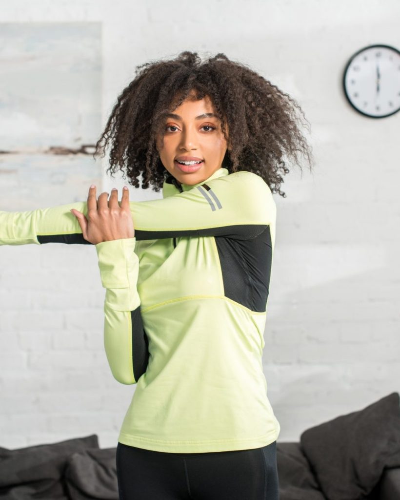 sportive african american girl warming up at home